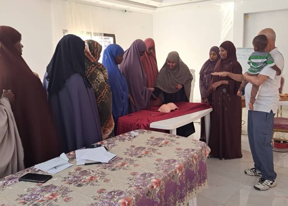 Participants practise breast examination on a training model